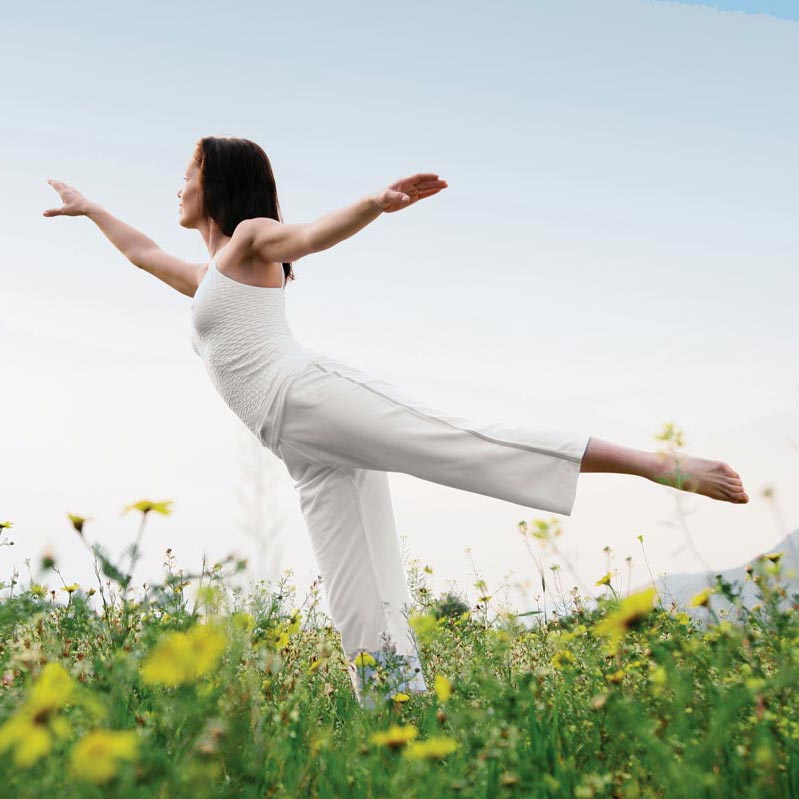 A woman doing yoga in a field. Northern Virginia Bioidentical Hormones doctor
